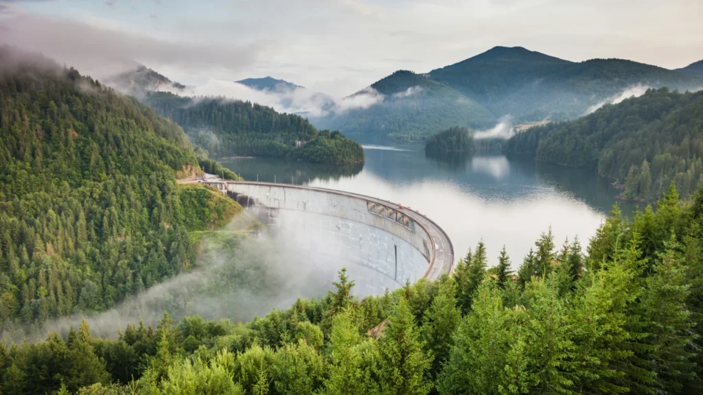 Presa rodeada por montañas y bosques en Rumanía, imagen asociada a las ventajas fiscales y residencia para emprendedores.