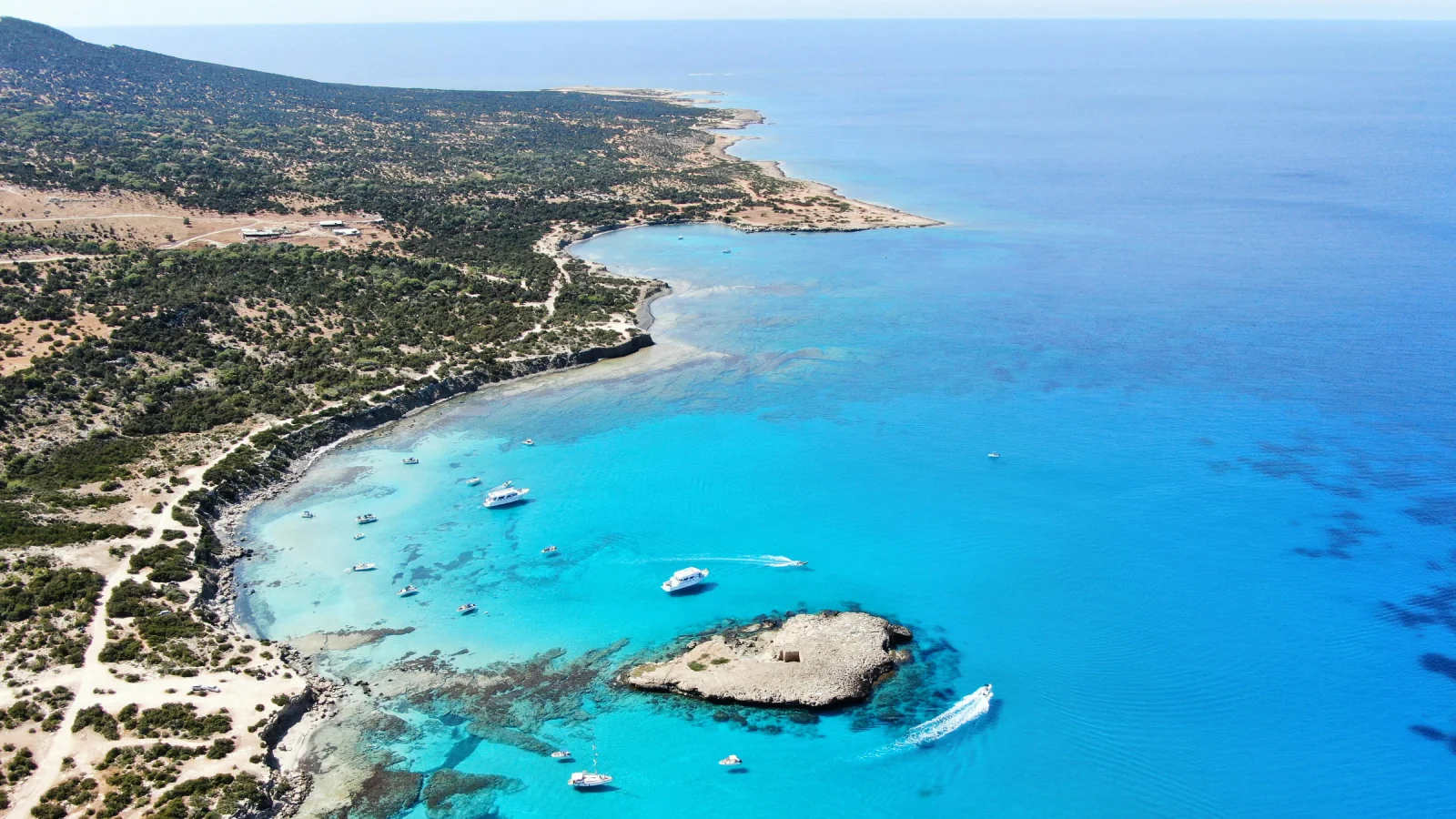 Vista aérea de la costa de Chipre con aguas turquesas y embarcaciones, destino popular para residencia fiscal non-dom