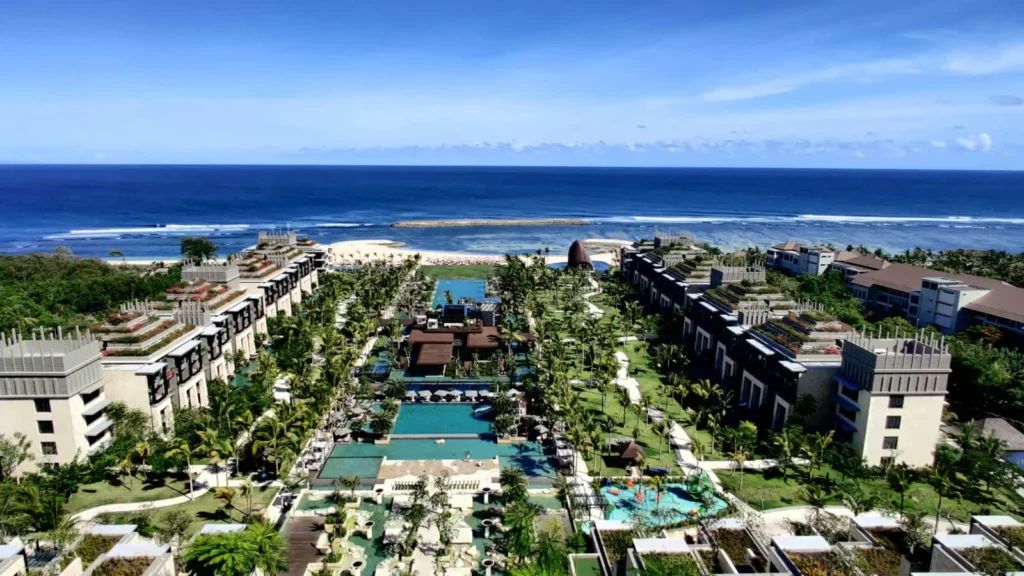 Vista panorámica de un complejo hotelero y residencial de lujo frente al mar en Bali, reflejando la infraestructura disponible para nómadas digitales.