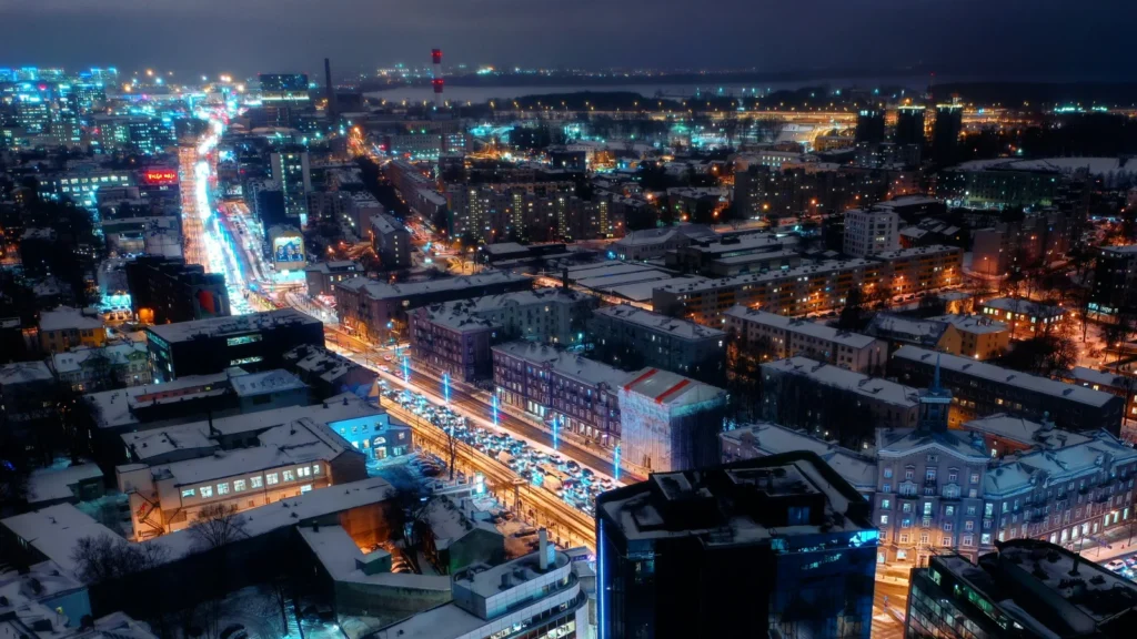 Vista aérea nocturna de la infraestructura y avenidas iluminadas de Tallin, representando la modernidad y digitalización de la e-Residency de Estonia.