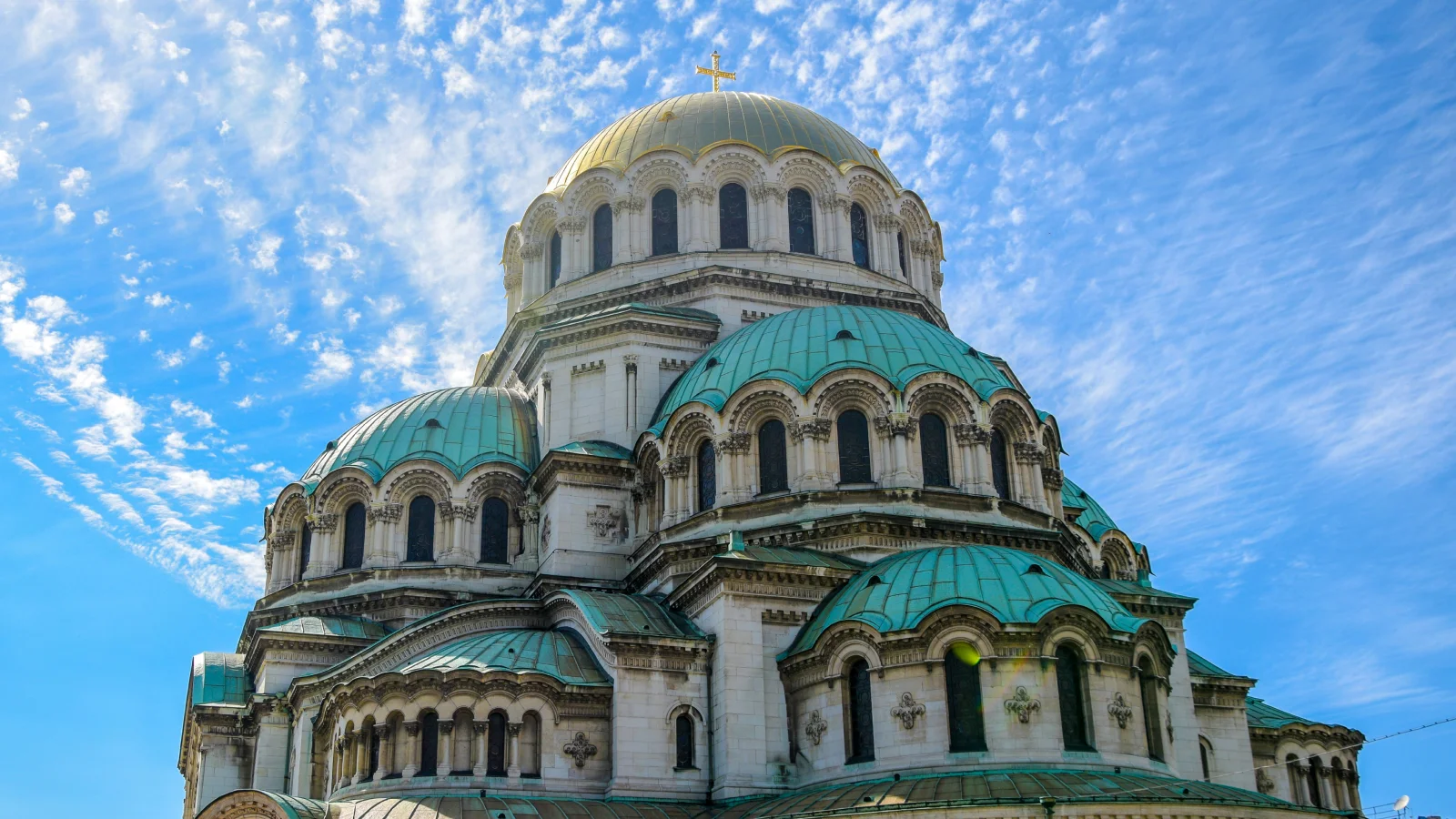 Catedral de Alejandro Nevski en Sofía bajo un cielo azul con nubes, representando la riqueza cultural y la residencia fiscal en Bulgaria.