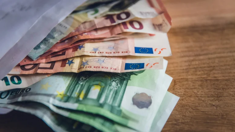 Detalle de un teclado y un monitor con datos financieros y líneas de código, representando la optimización fiscal y la deducción en el IRPF por invertir en empresas de nueva creación.
