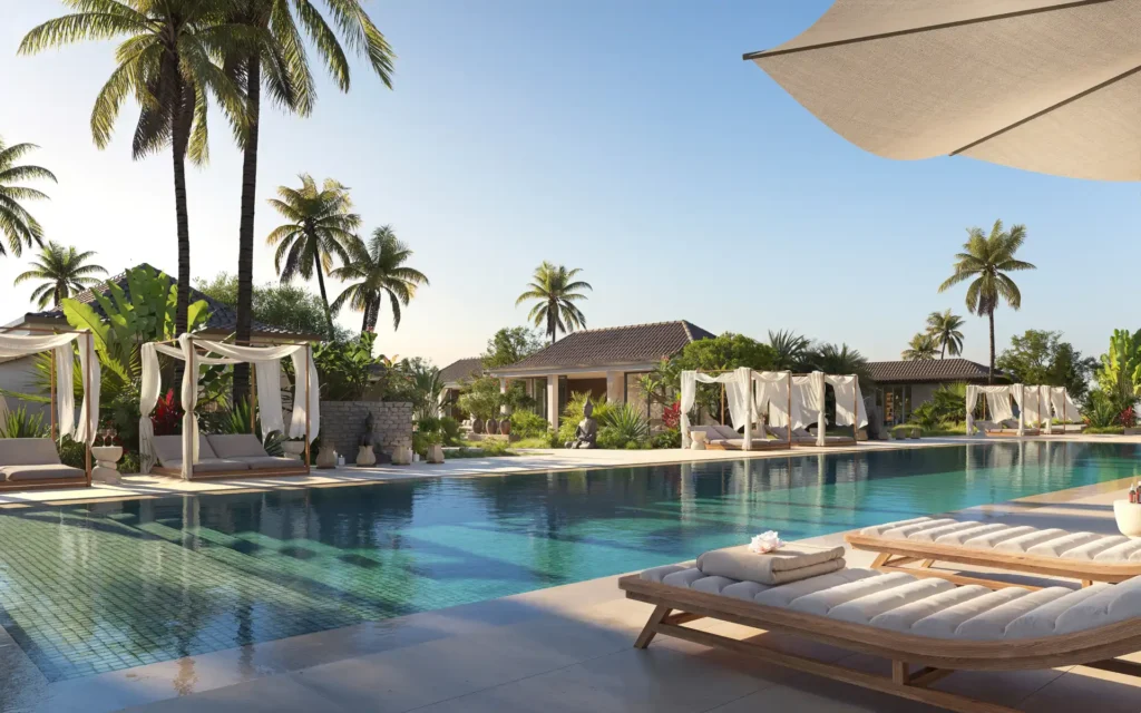 Piscina de resort en Bali rodeada de palmeras y camas balinesas al atardecer